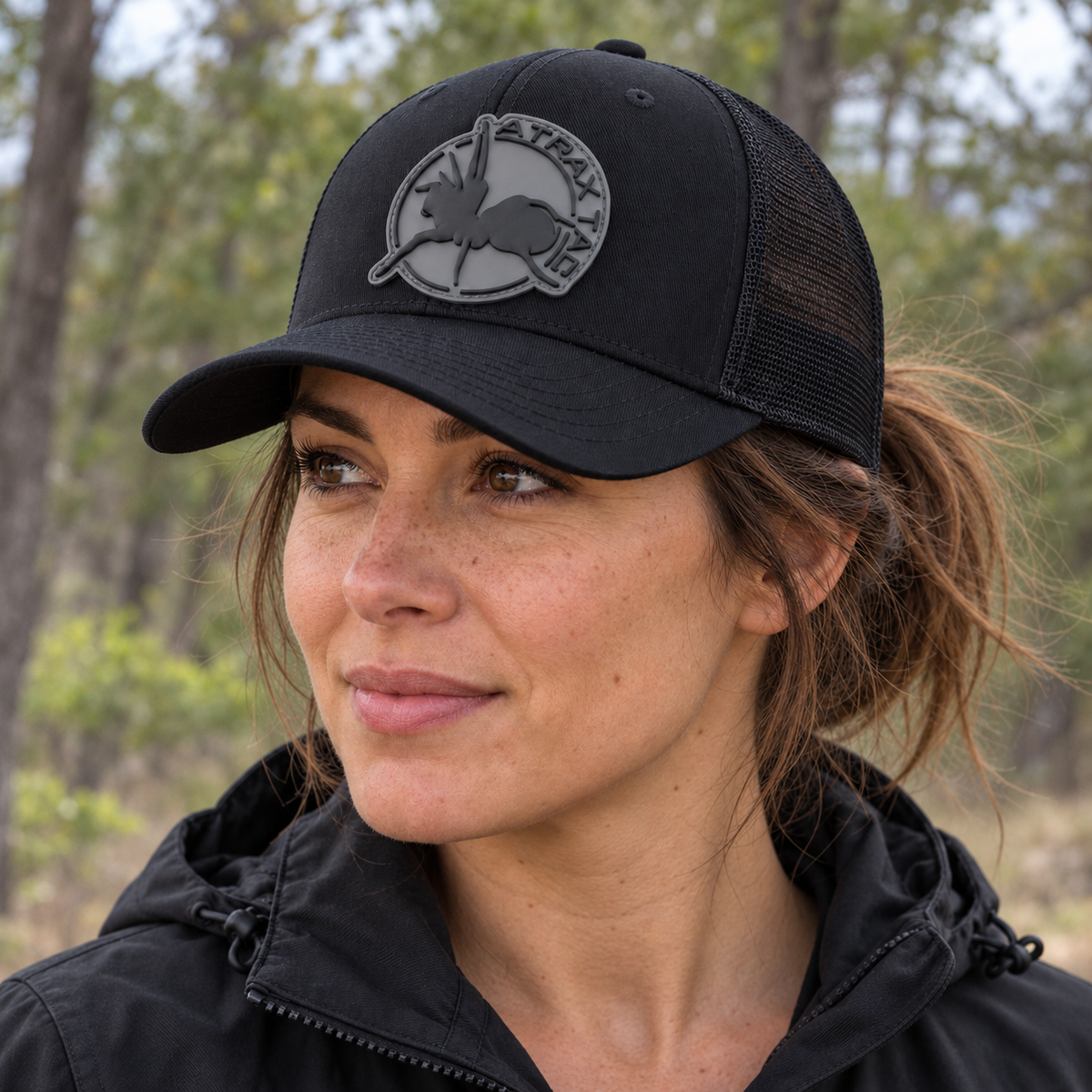 Black AtraxTac cap with gray logo worn by a woman