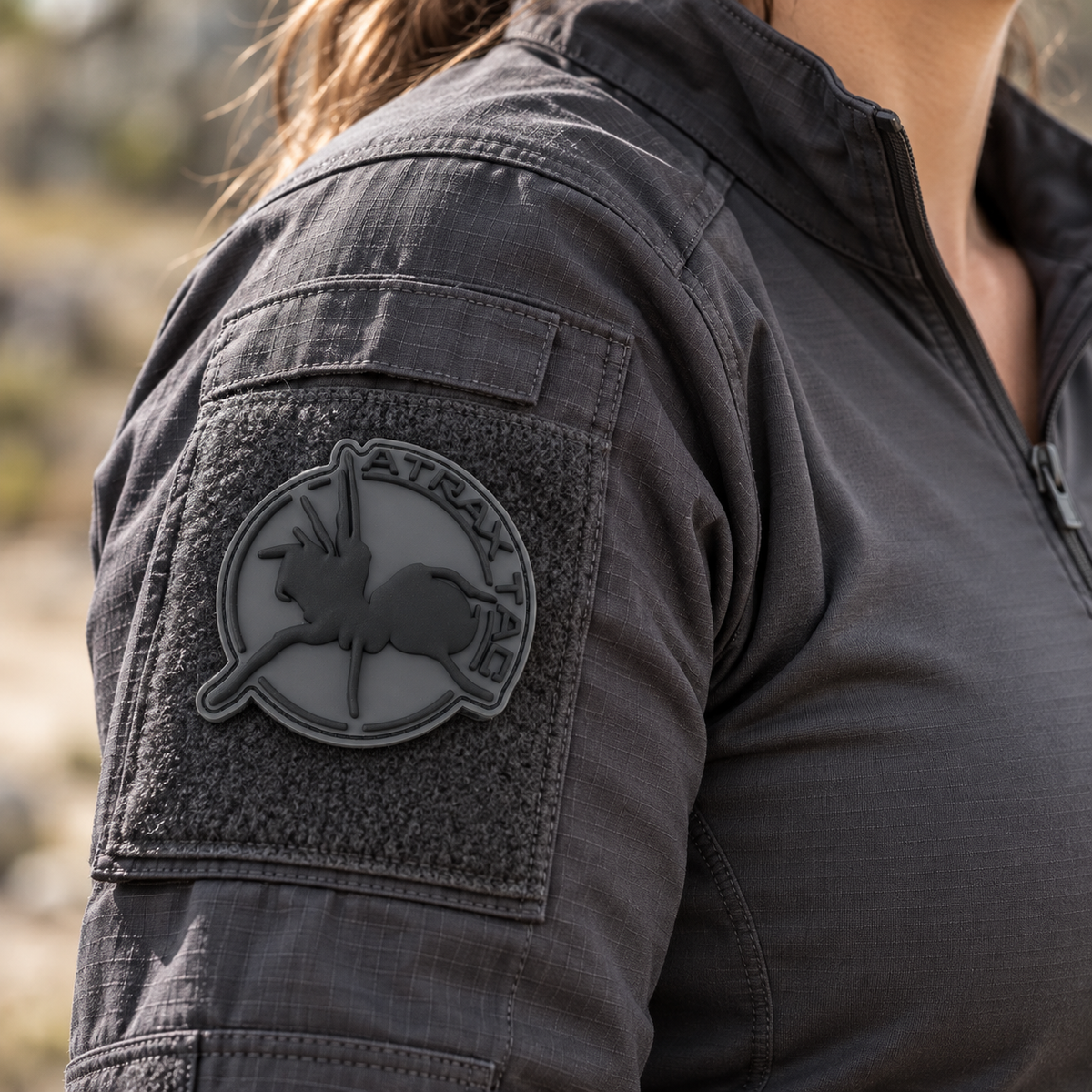 Gray AtraxTac PVC patch on a charcoal combat shirt sleeve