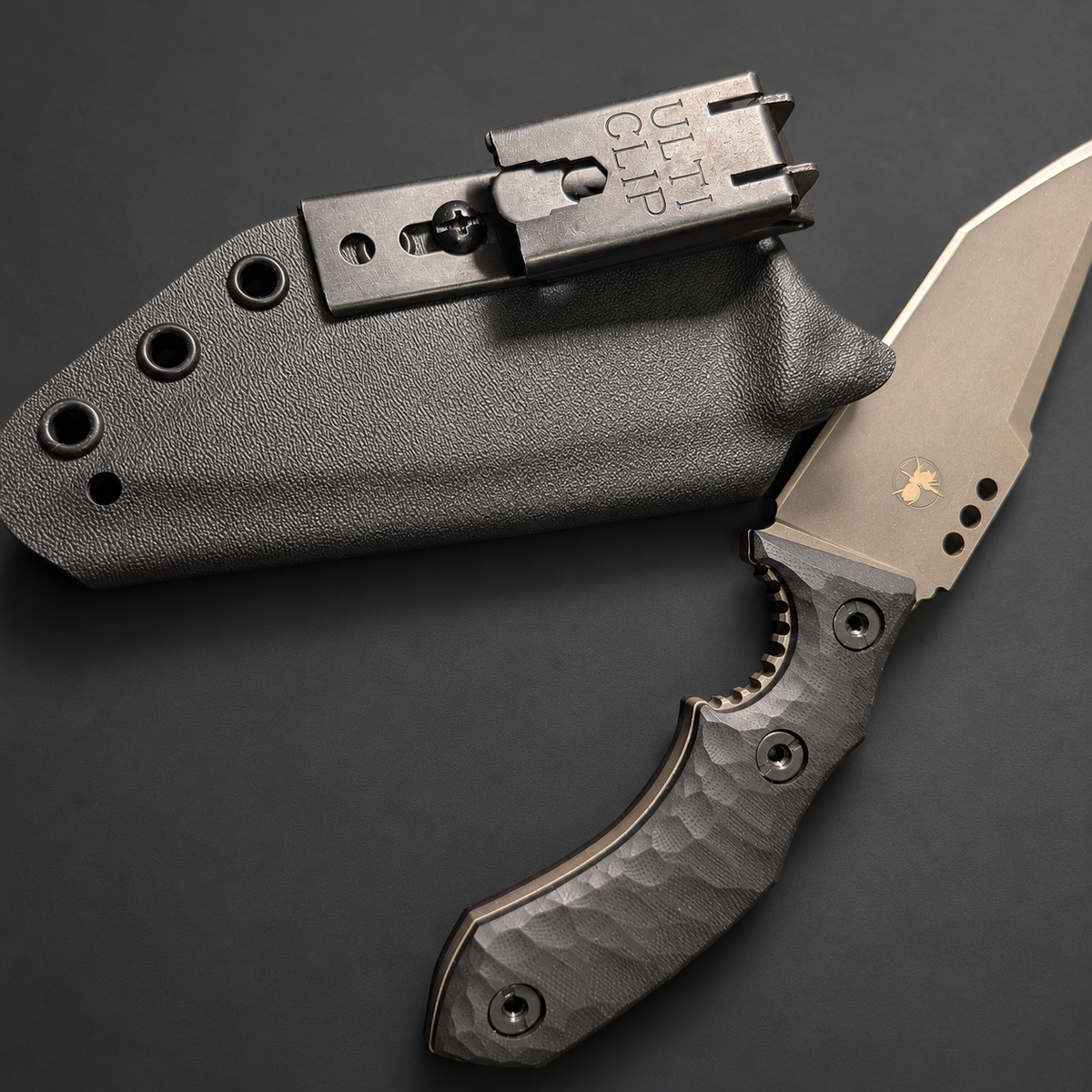 ULTICLIP XL mounted on a black sheath beside a knife; mounting example, knife and sheath not included